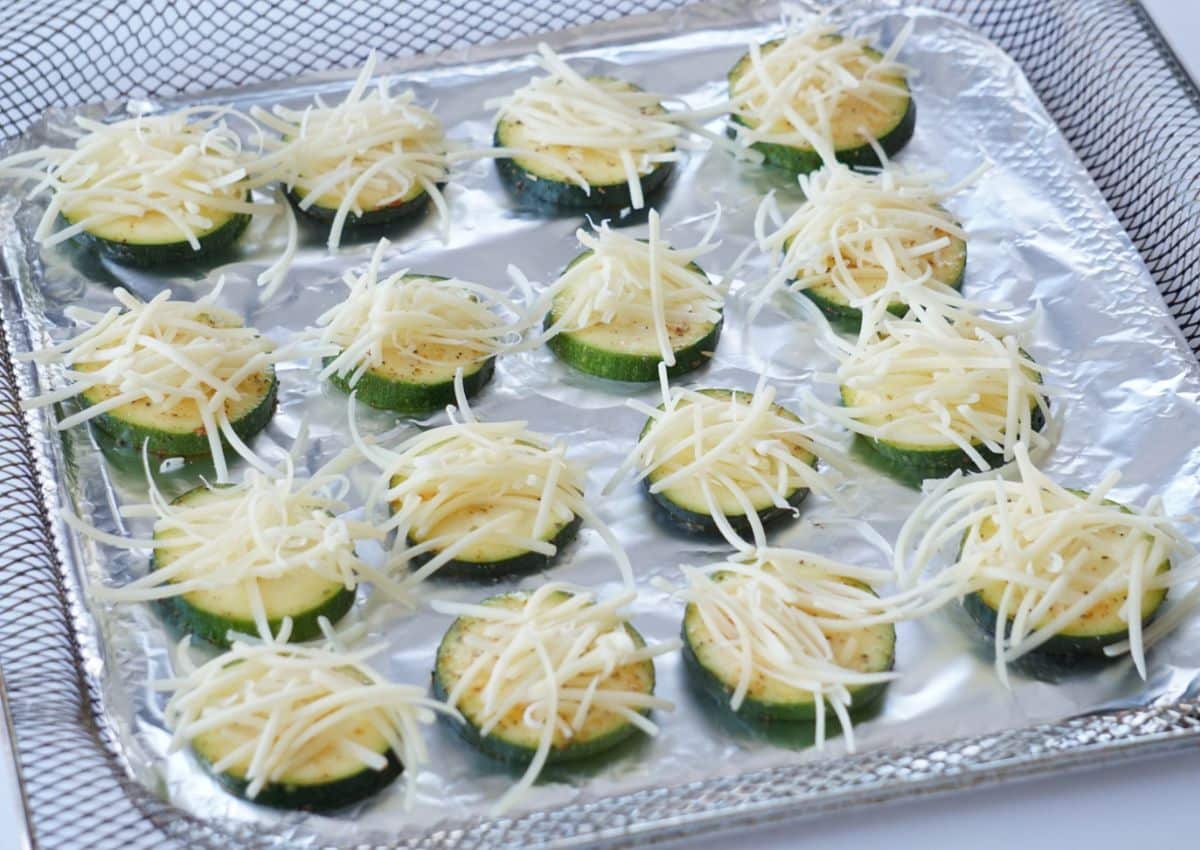 zucchini in a air fryer basket with cheese