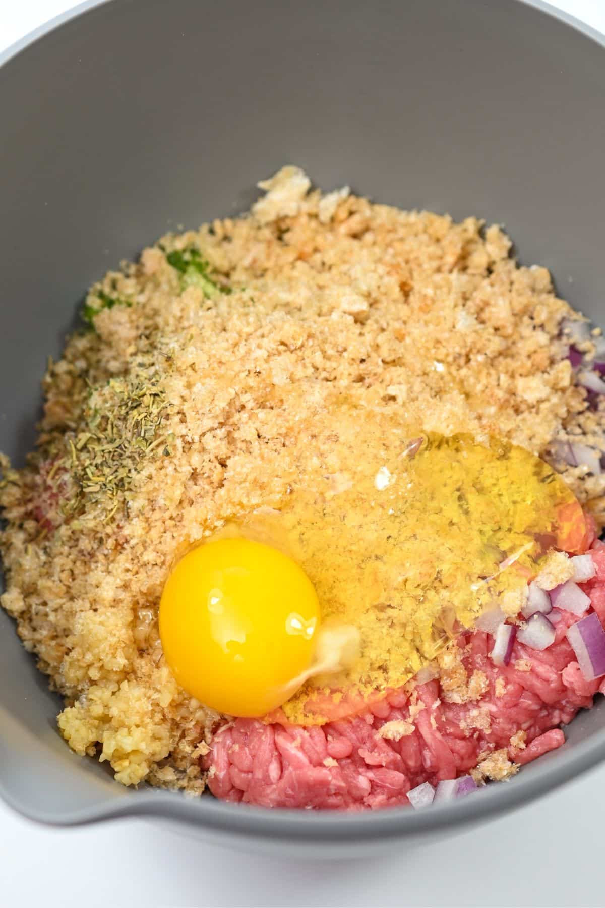 ground turkey, onion, peppers, garlic, egg, pork rind crumbs, Italian seasoning and salt and pepper to taste to a large mixing bowl